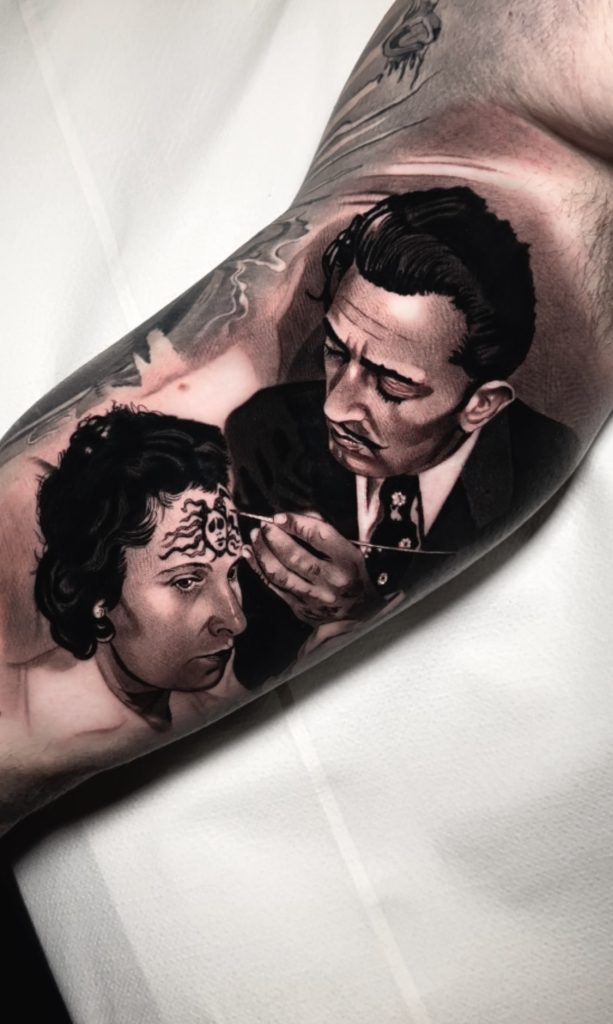 Tatuaje realista de un hombre pintando en la frente de una mujer