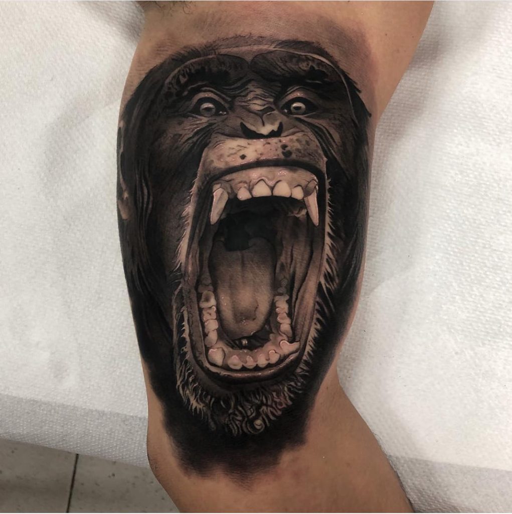 Tatuaje hiperrealista de un gorila rugiendo en el brazo